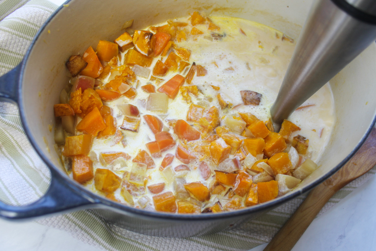 A pot of chunky roasted butternut squash and carrot soup, ready to be blended with cream.