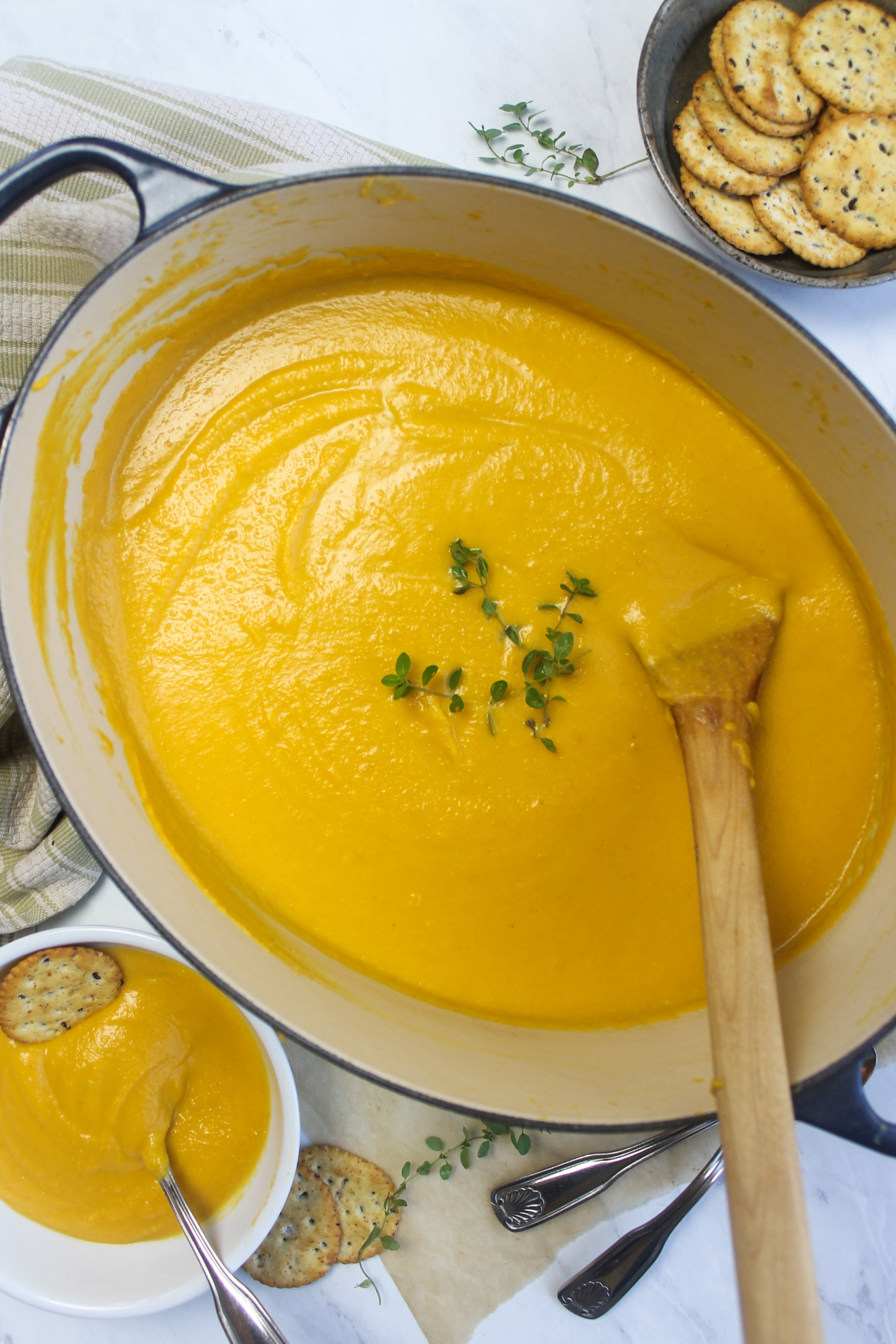 A Dutch oven pot of creamy butternut squash carrot soup.