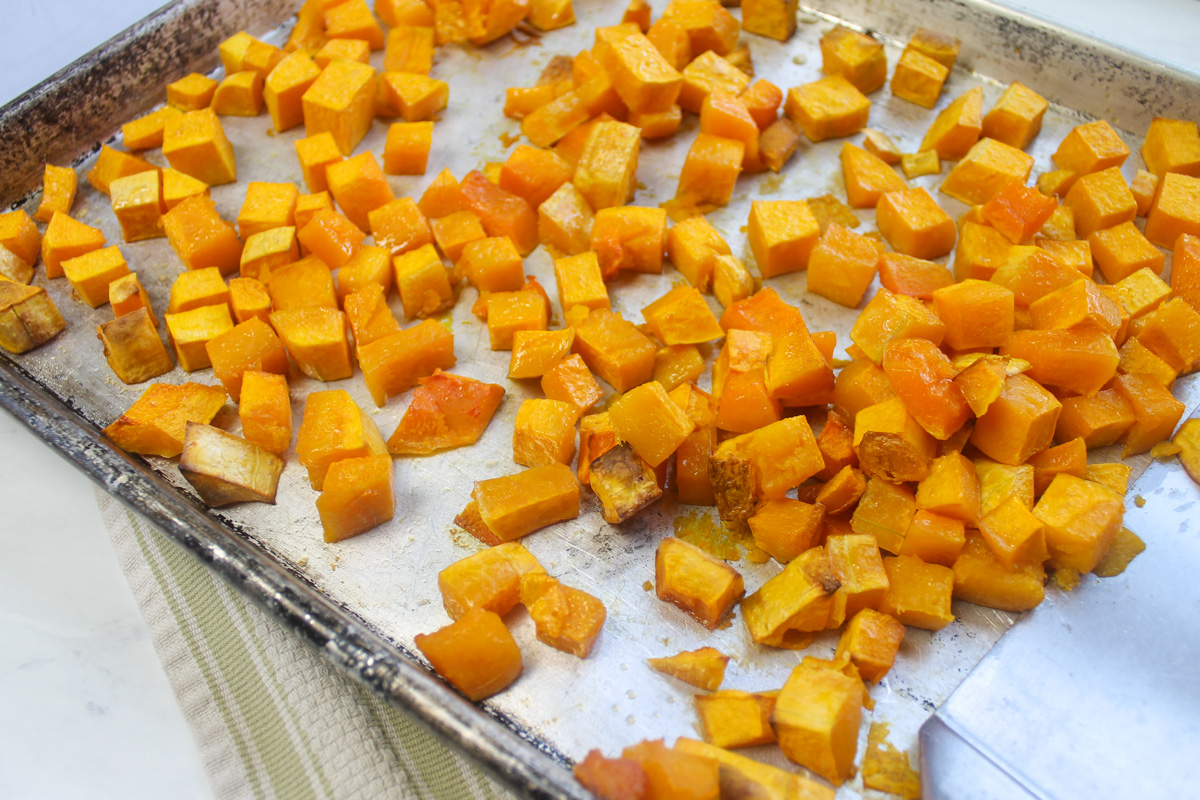 A sheet pan of cubed butternut squash that has been roasted in the oven.