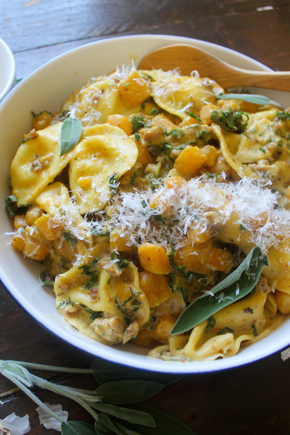 Bowl of ravioli with with sausage, butternut squash and kale.