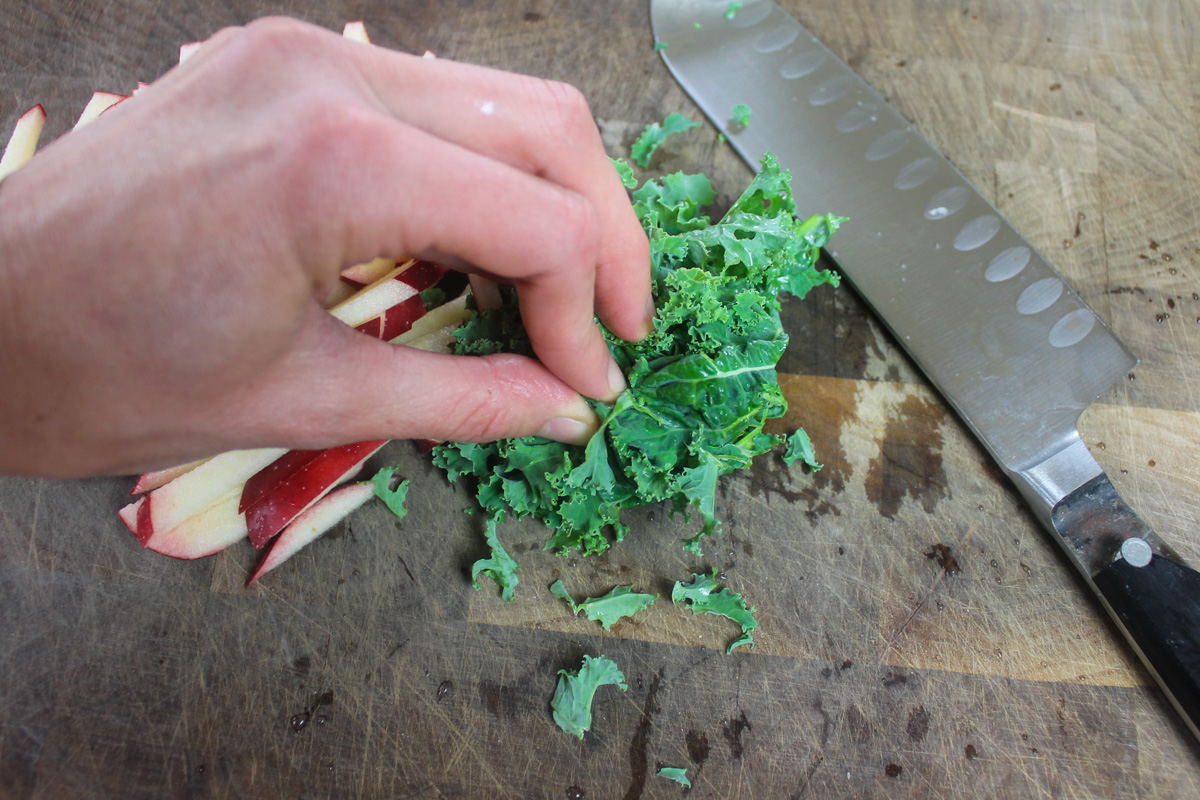 Thinly slicing kale leaves for kale apple slaw.