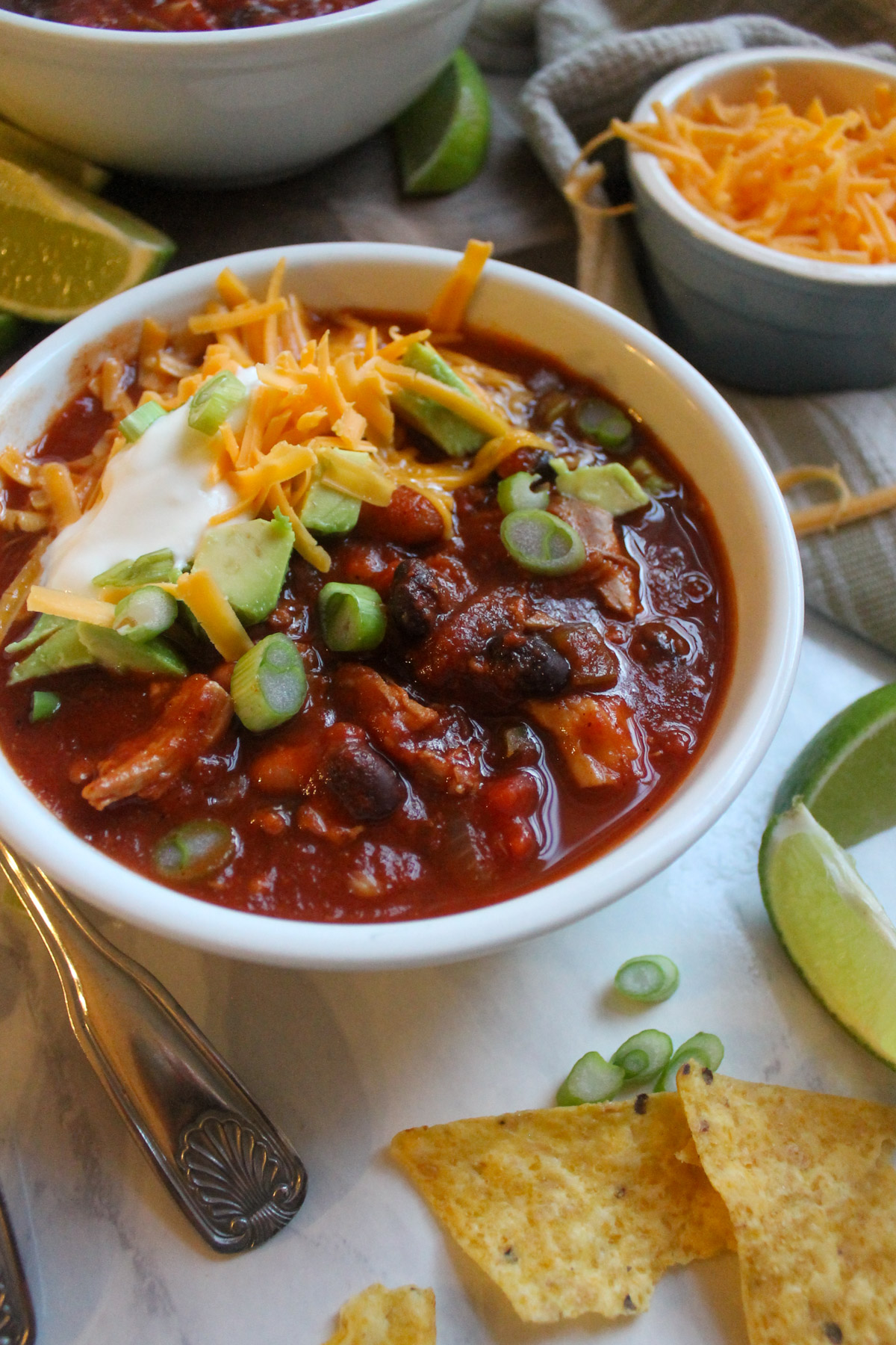 A bowl of leftover turkey chili with black beans and lime.