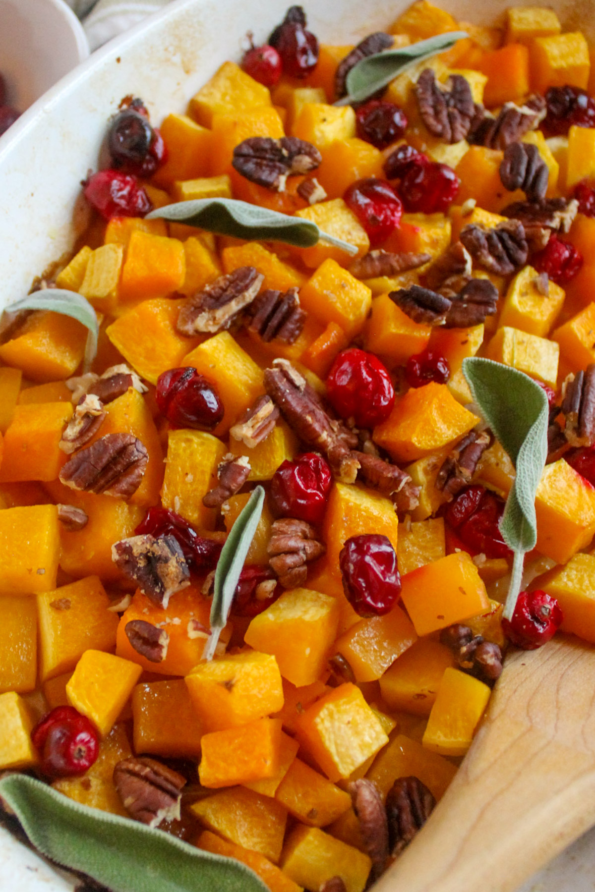 Butternut squash and cranberries roasted in a casserole serving dish.