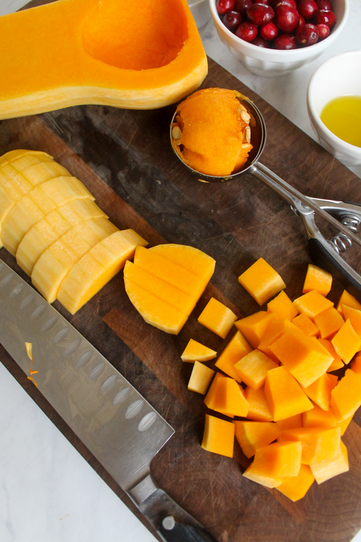 Chopping fresh butternut squash on a cutting board.