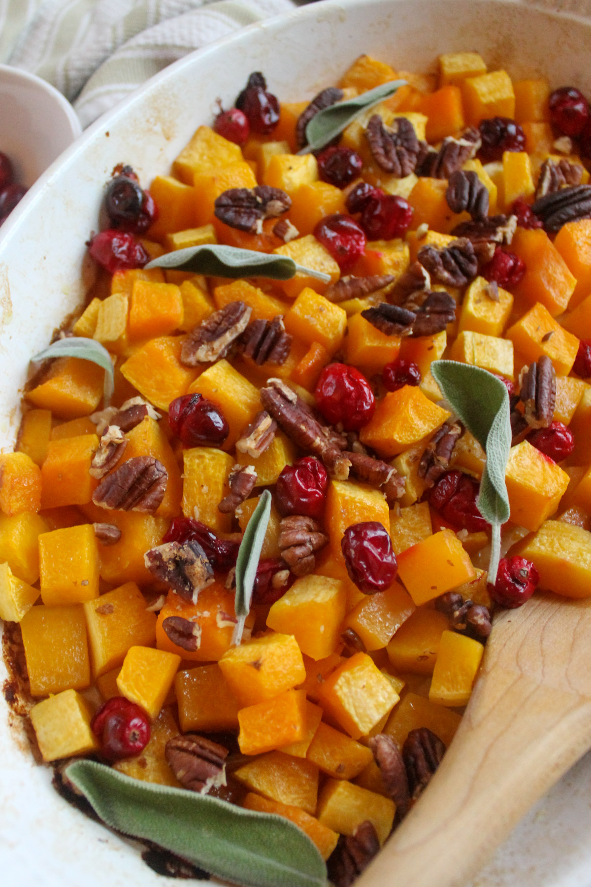 Butternut squash and cranberries roasted in a casserole serving dish.