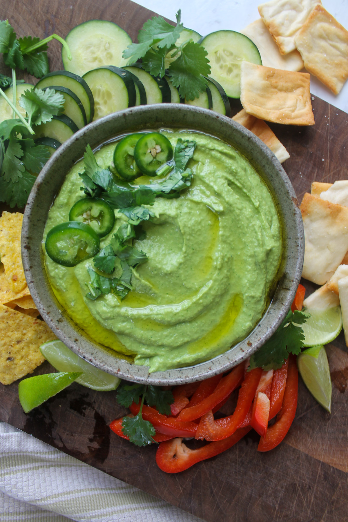 Cilantro hummus on a snack board of veggies and chips.
