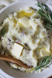 Close up of garlic redskin mashed potatoes with melting butter and rosemary.