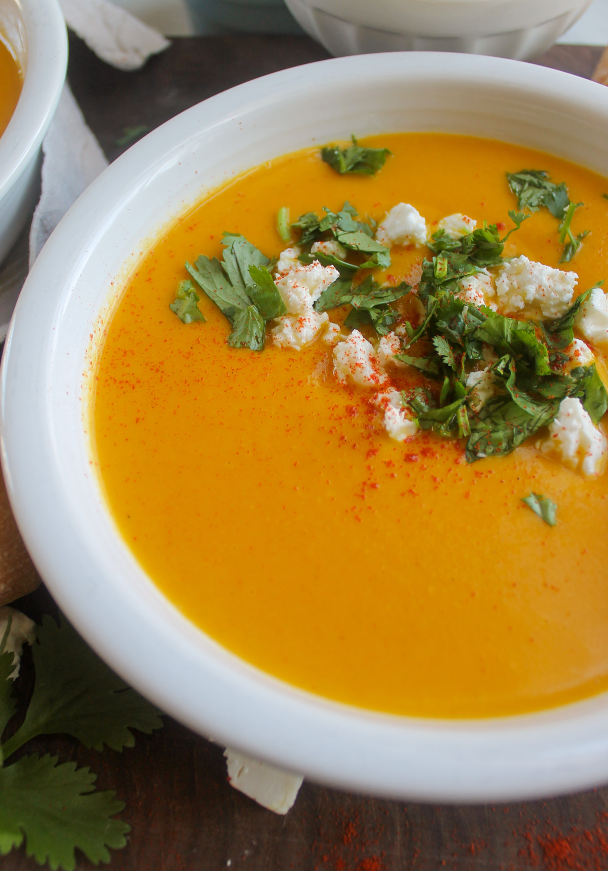 Close up of bright orange carrot ginger soup with fresh cilantro.