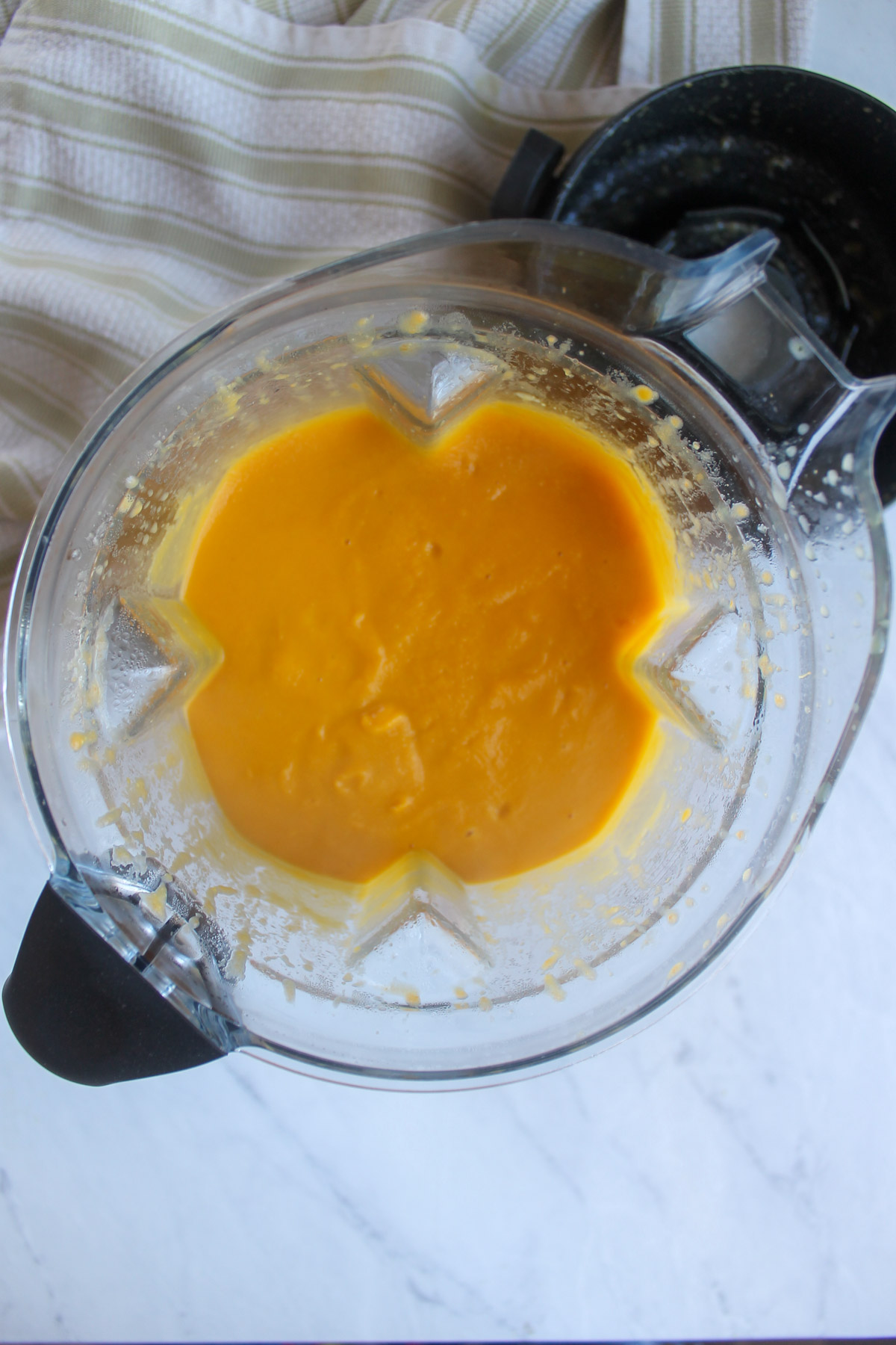 A blender with the pureed carrot and chickpea soup.