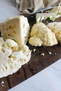 Quartering a head of cauliflower and removing the core.