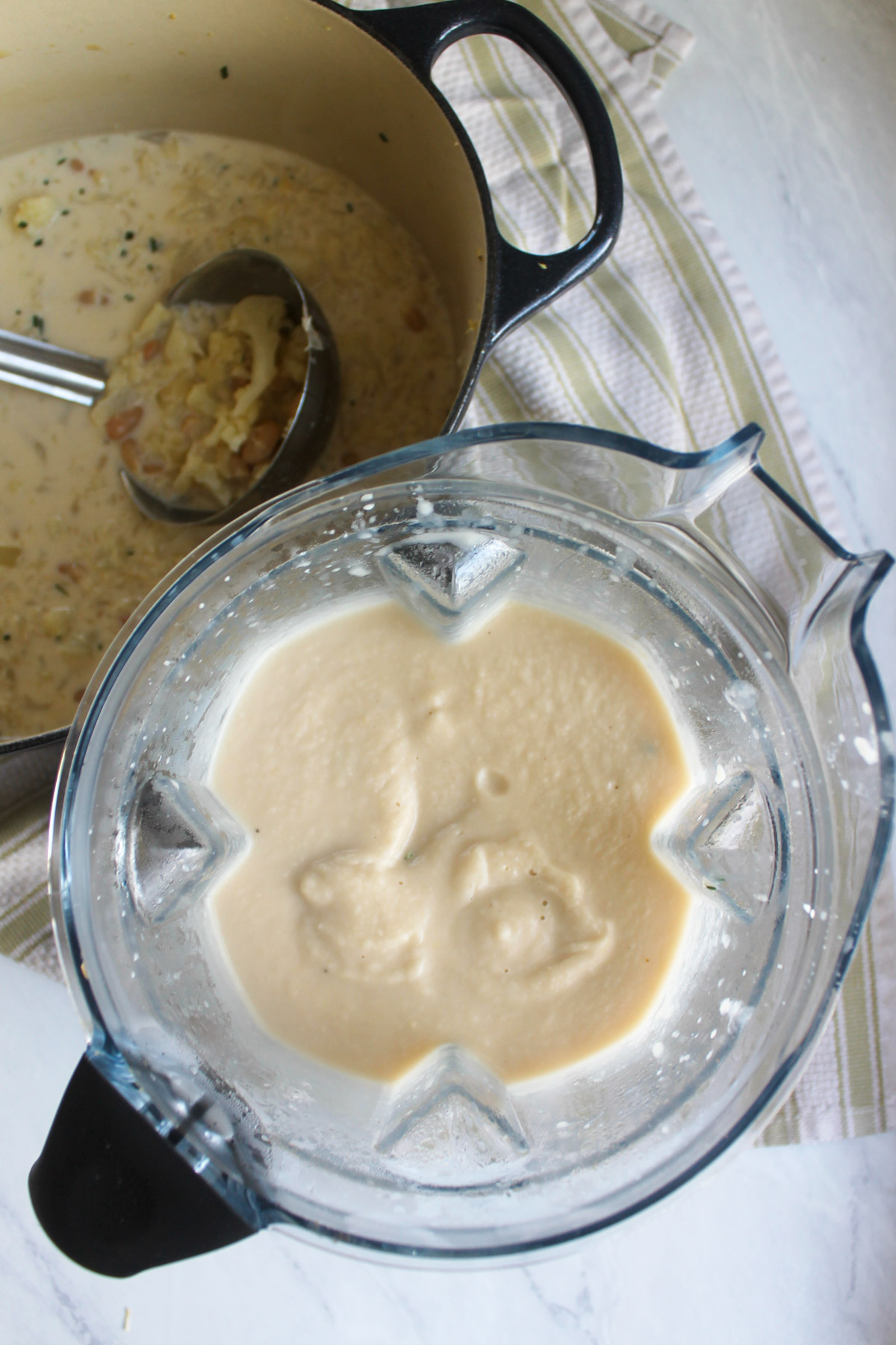 Pureeing cauliflower white bean soup in a high speed blender in batches.