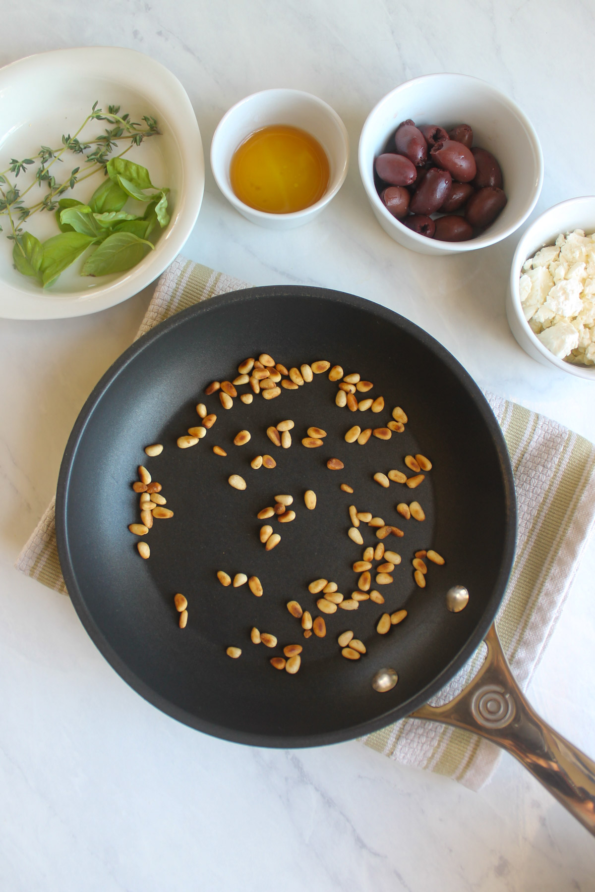 Toasting pine nuts in a skillet.