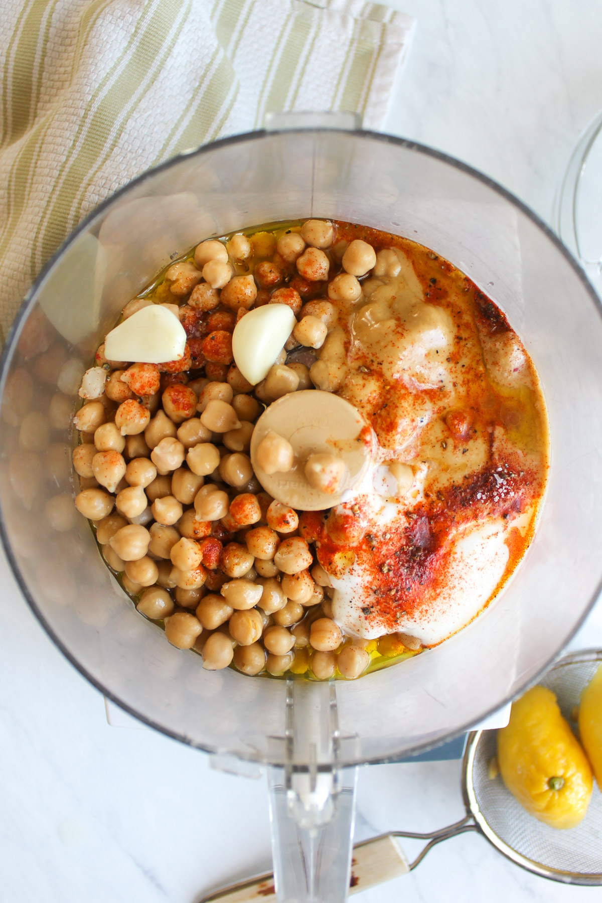 Mediterranean hummus ingredients in the bowl of a food processor.