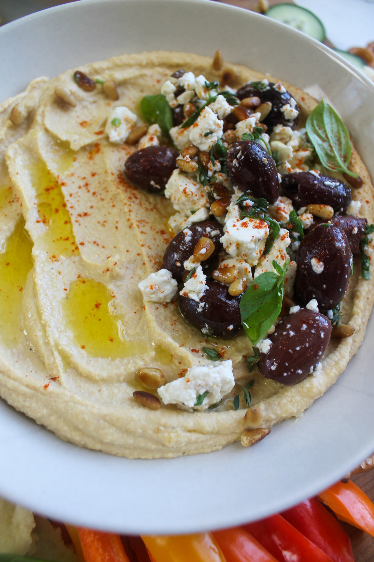 Close up of Mediterranean hummus with olives and feta topping.