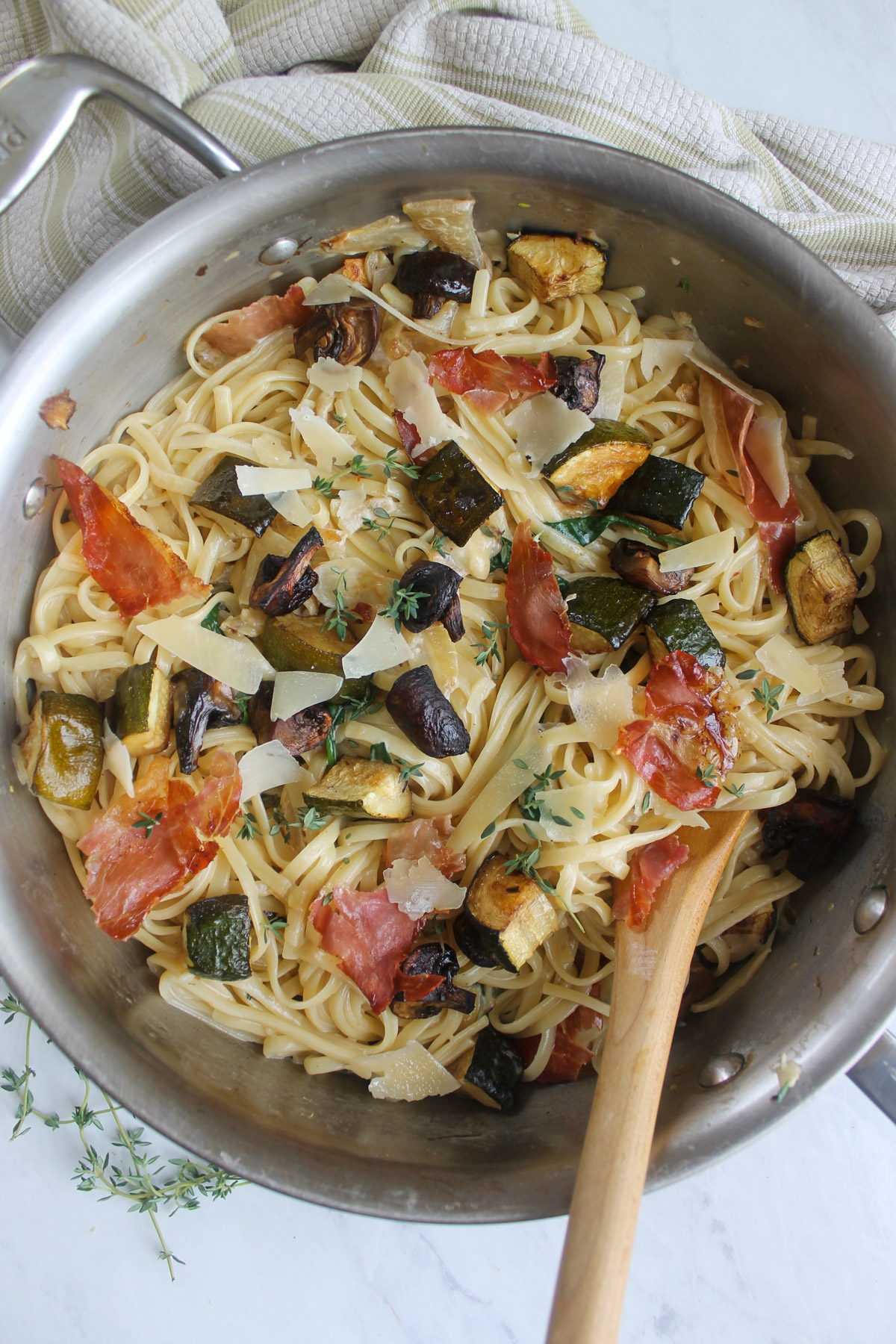 The completed dish, creamy linguine pasta topped with roasted zucchini, mushrooms and crispy prosciutto.