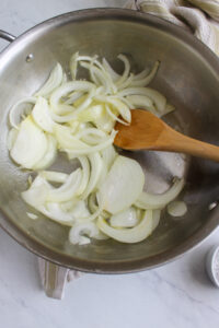 Raw onions in a skillet ready to caramelize.