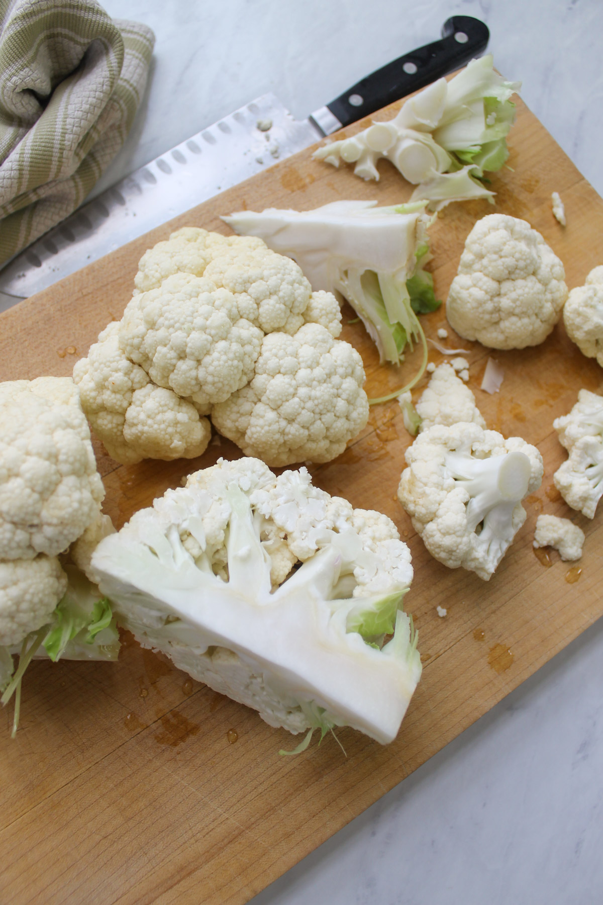 Cutting a head of cauliflower into quarters to remove the core.