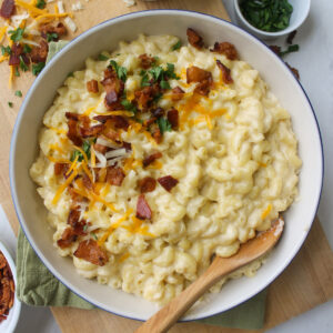 A bowl of bacon cauliflower mac and cheese with extra cheese and bacon on top.