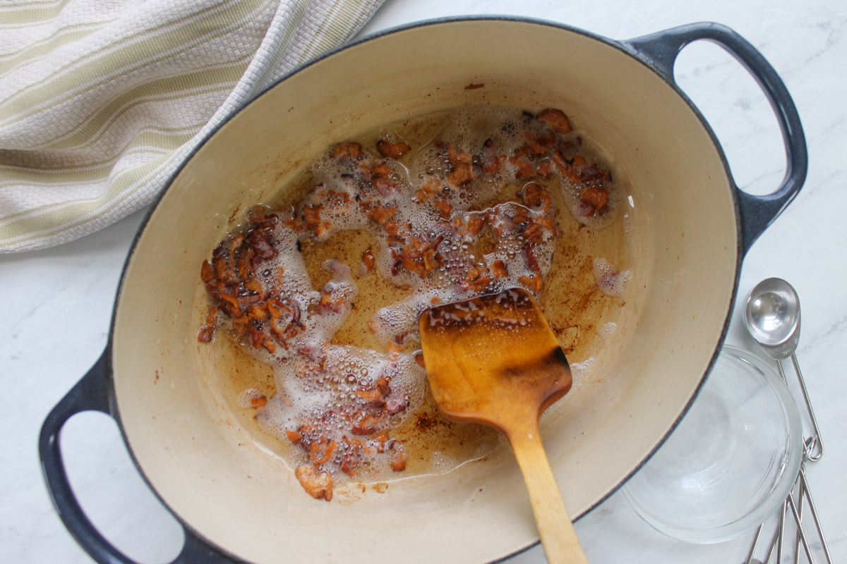 Cooking chopped bacon in a pot until crisp.