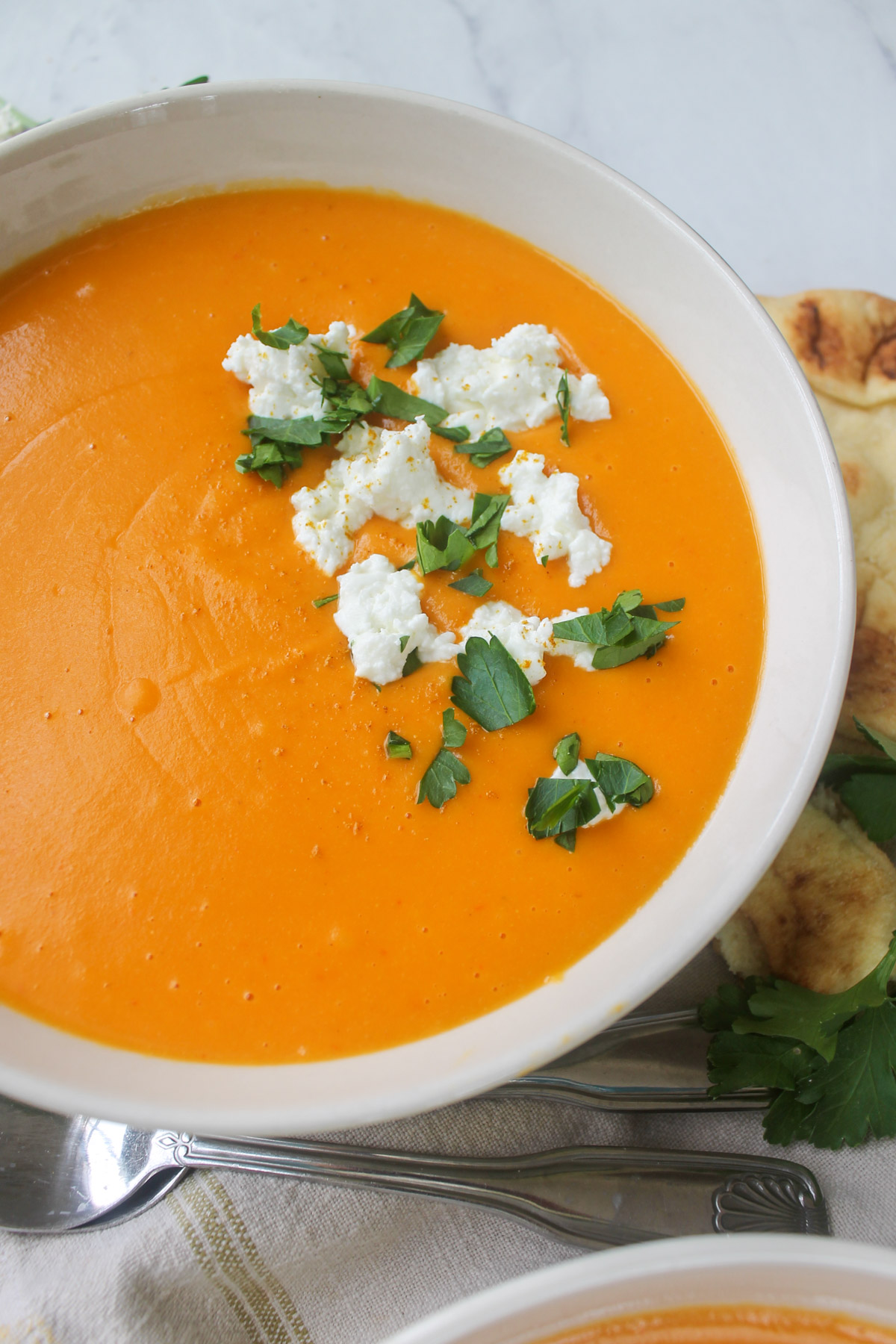 Butternut squash orange soup with goat cheese crumbles and chopped parsley.