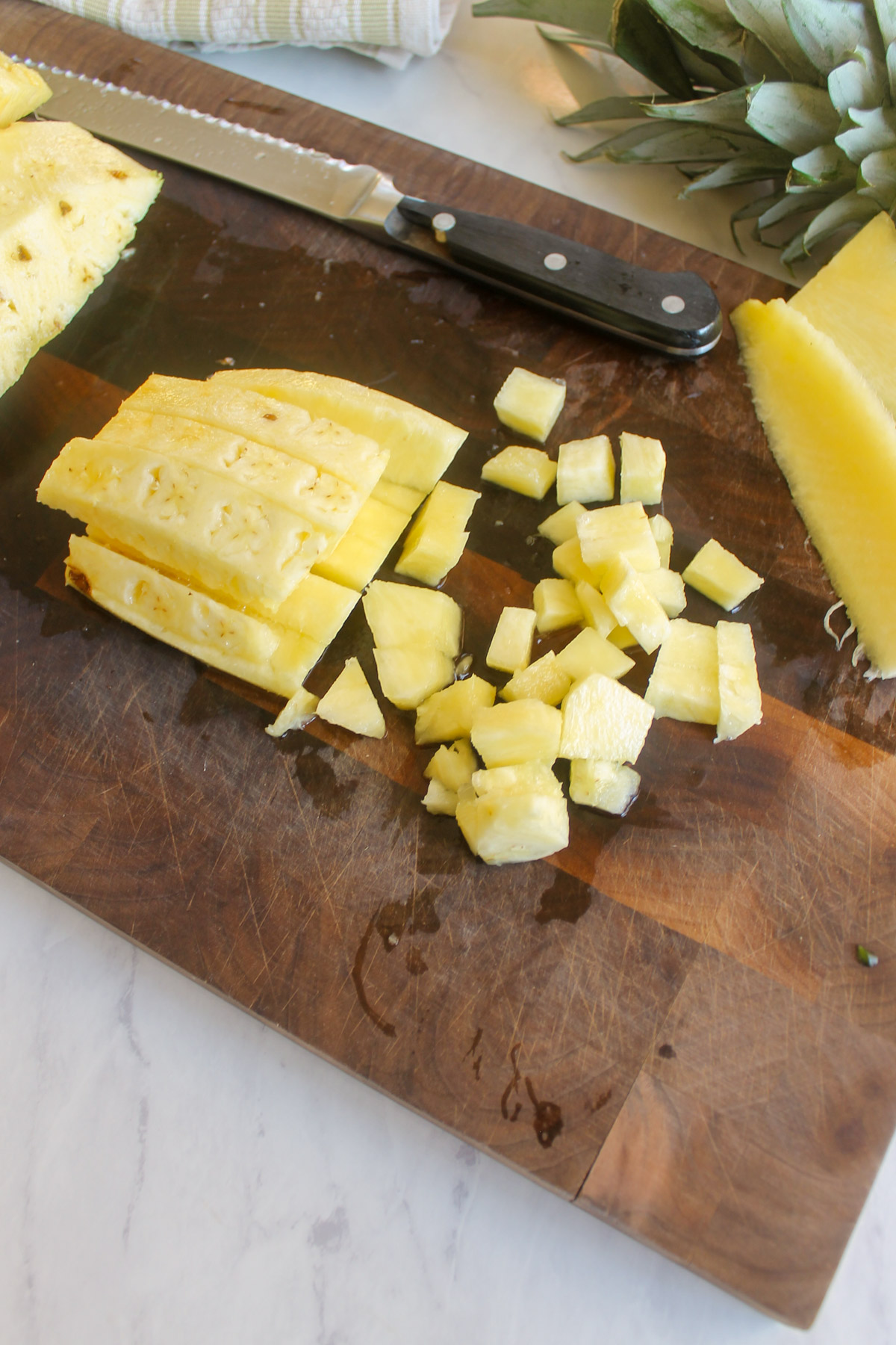 Chopping a pineapple into small cubes for pico de gallo.