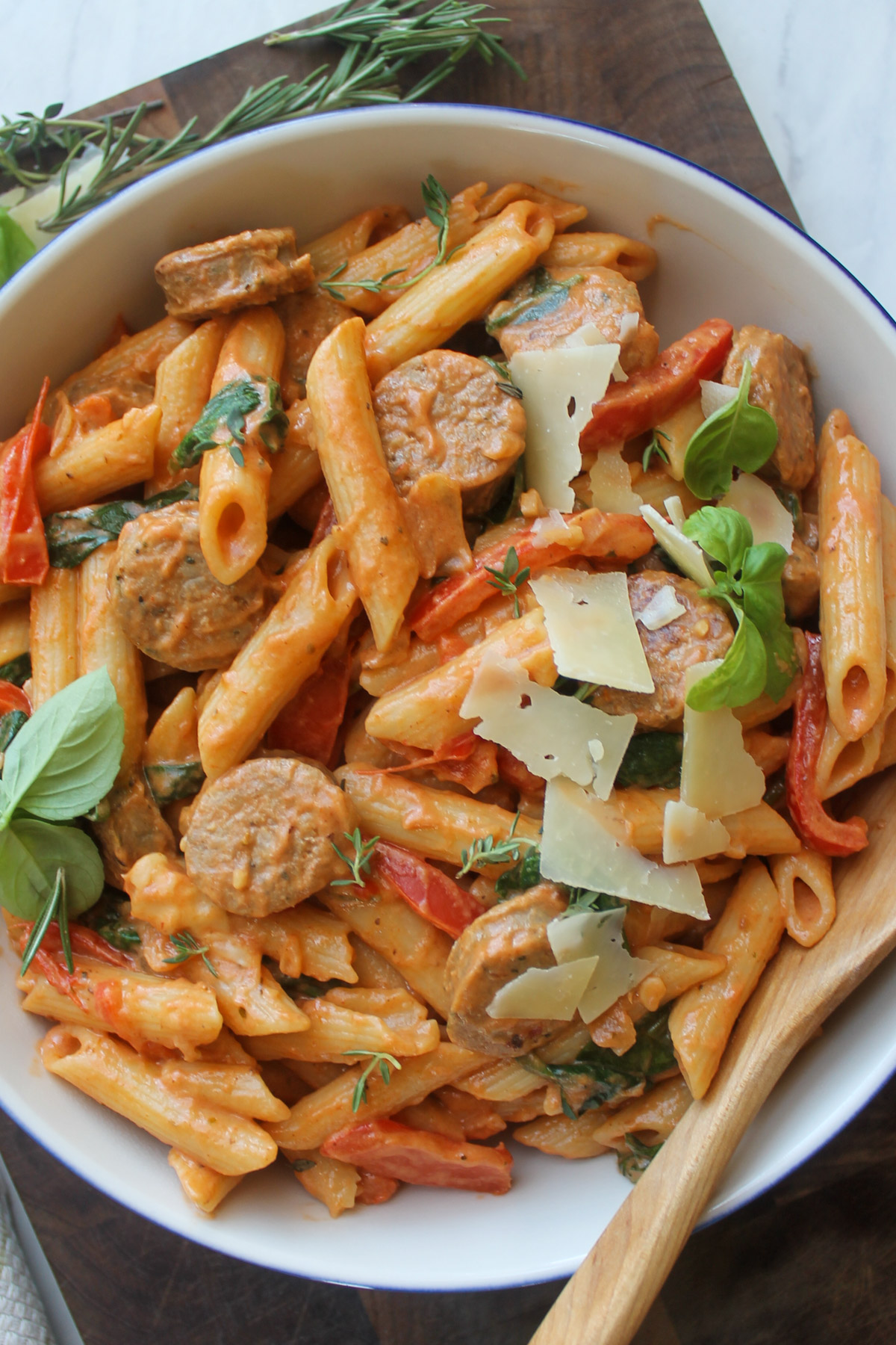 A bowl of penne pasta with creamy tomato sauce and Parmesan cheese.