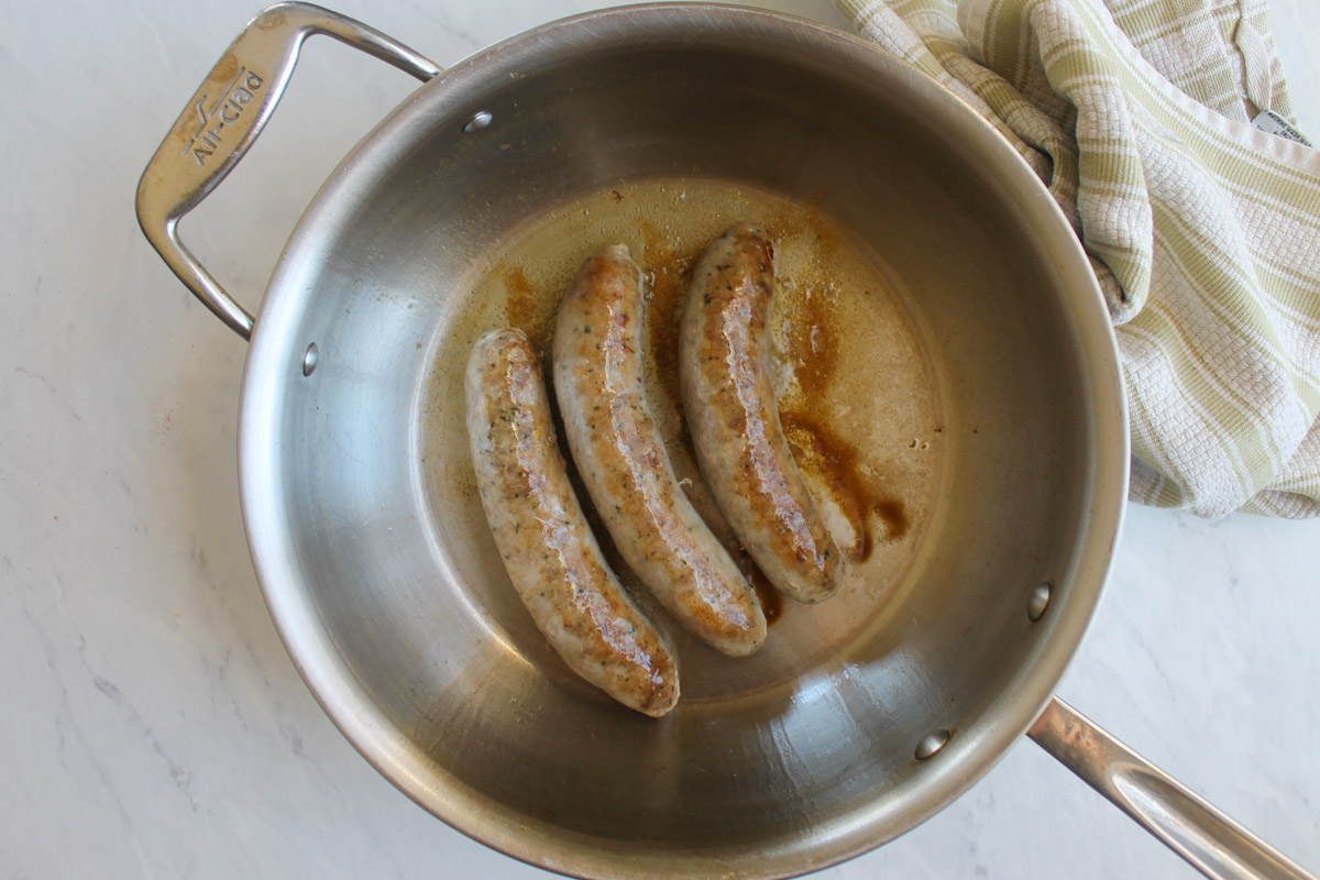 Browning the Italian sausages in a skillet.