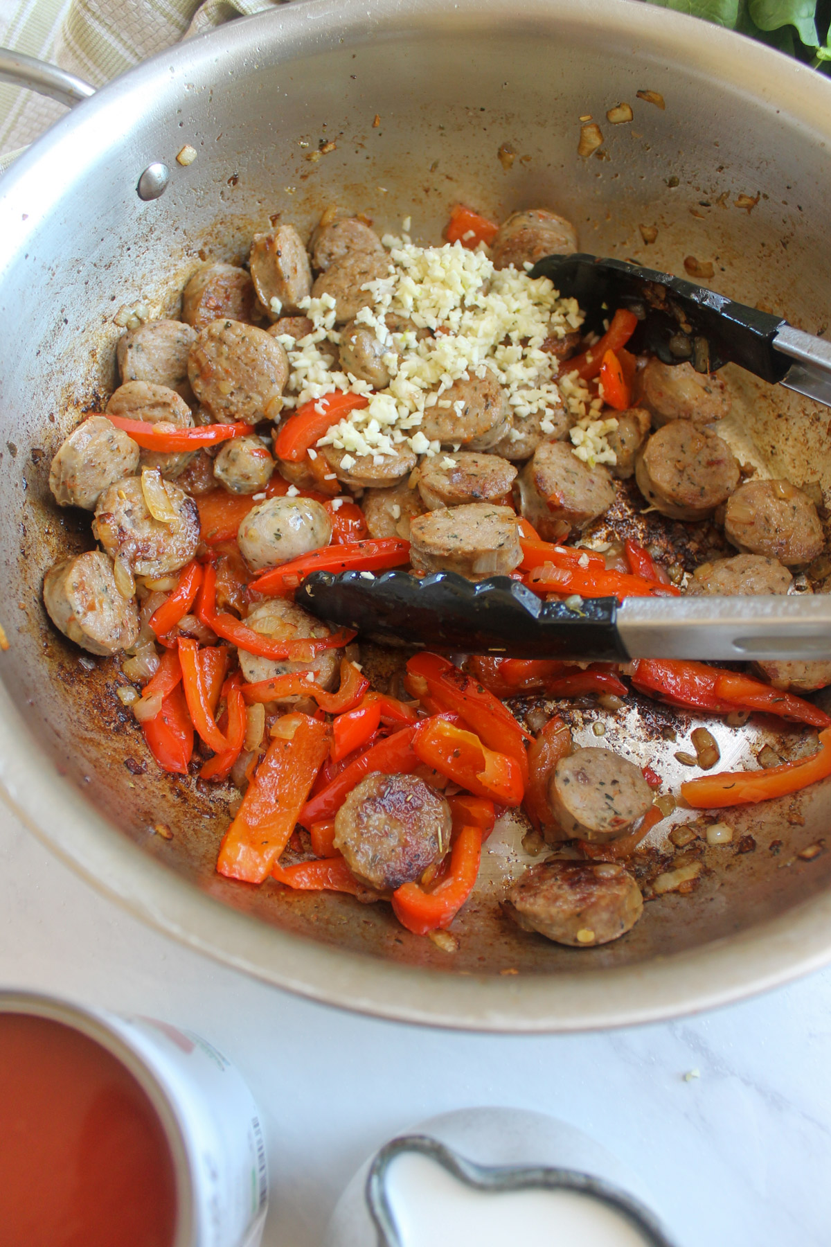 The sliced sausage links added back to the skillet with the onions, red bell pepper and garlic.