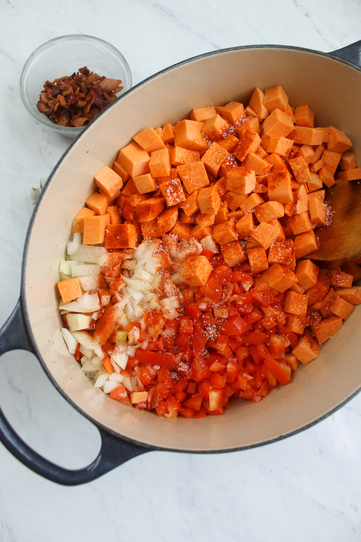 Starting to cook sweet potatoes, onion and red peppers in a soup pot.