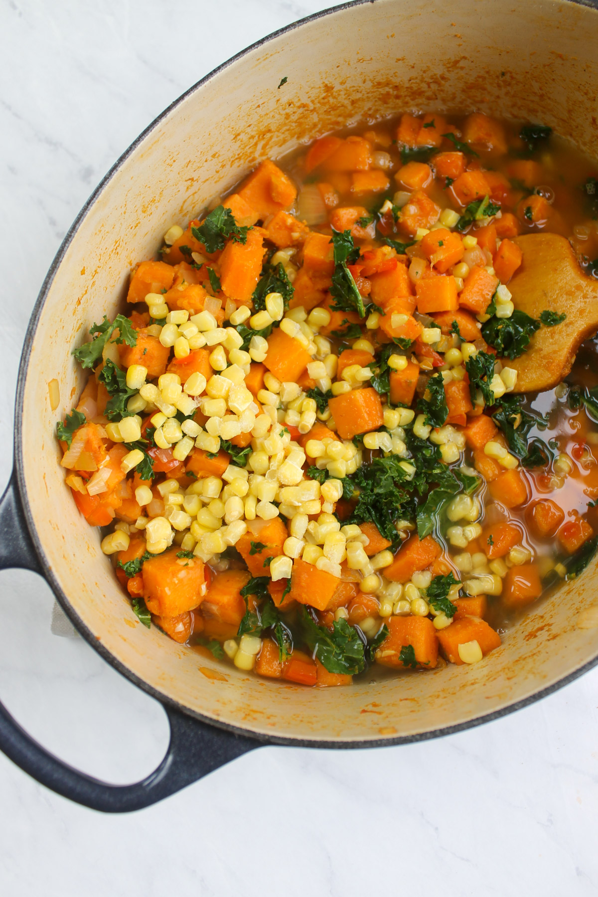 Adding the corn and stock to the sweet potato corn chowder.