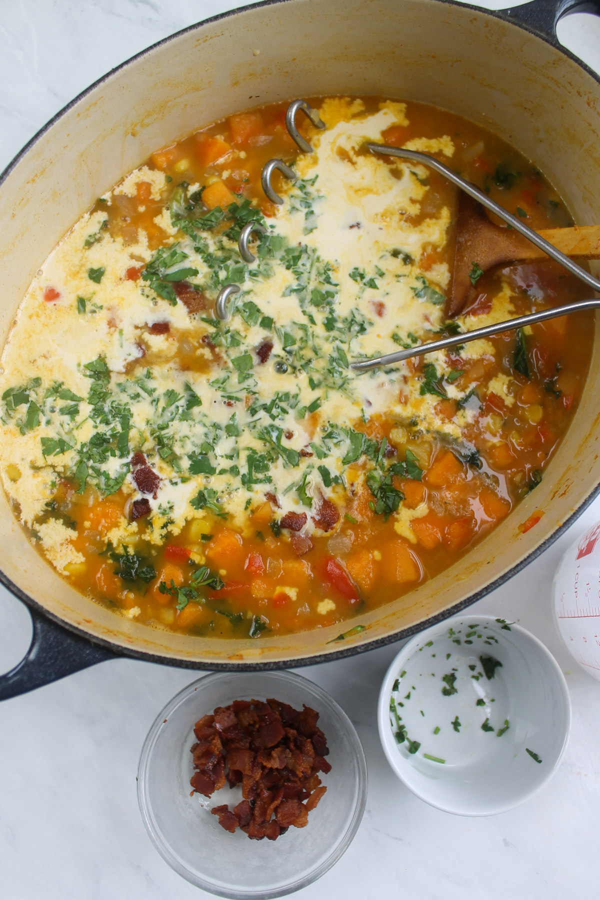 Adding the half and half to the chowder and using a potato masher to break up the sweet potatoes.