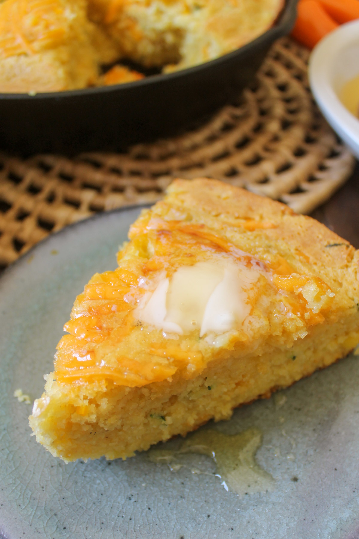 A slice of skillet cornbread on a blue plate.