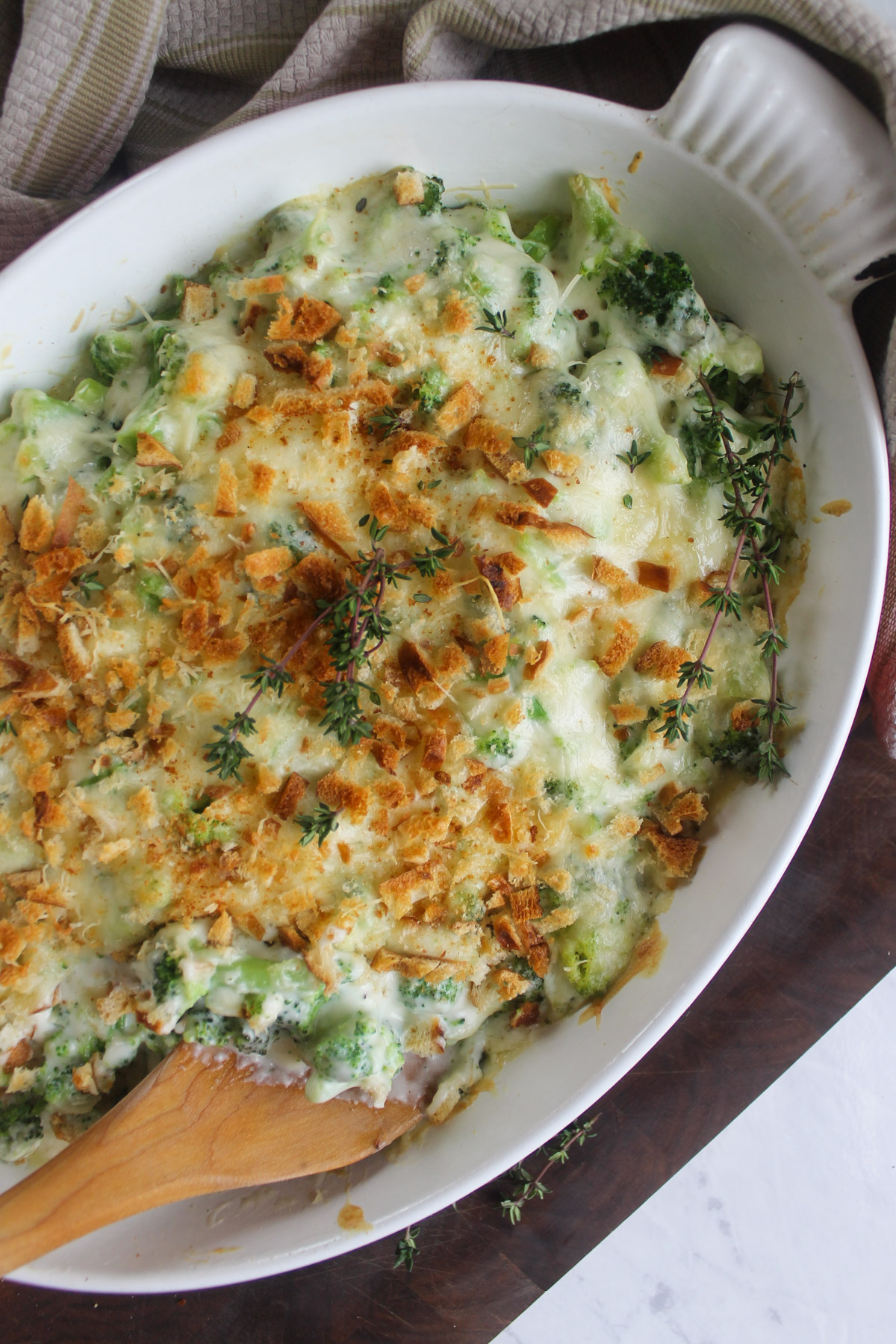 A dish of baked broccoli and white cheddar cheese casserole browned on top.