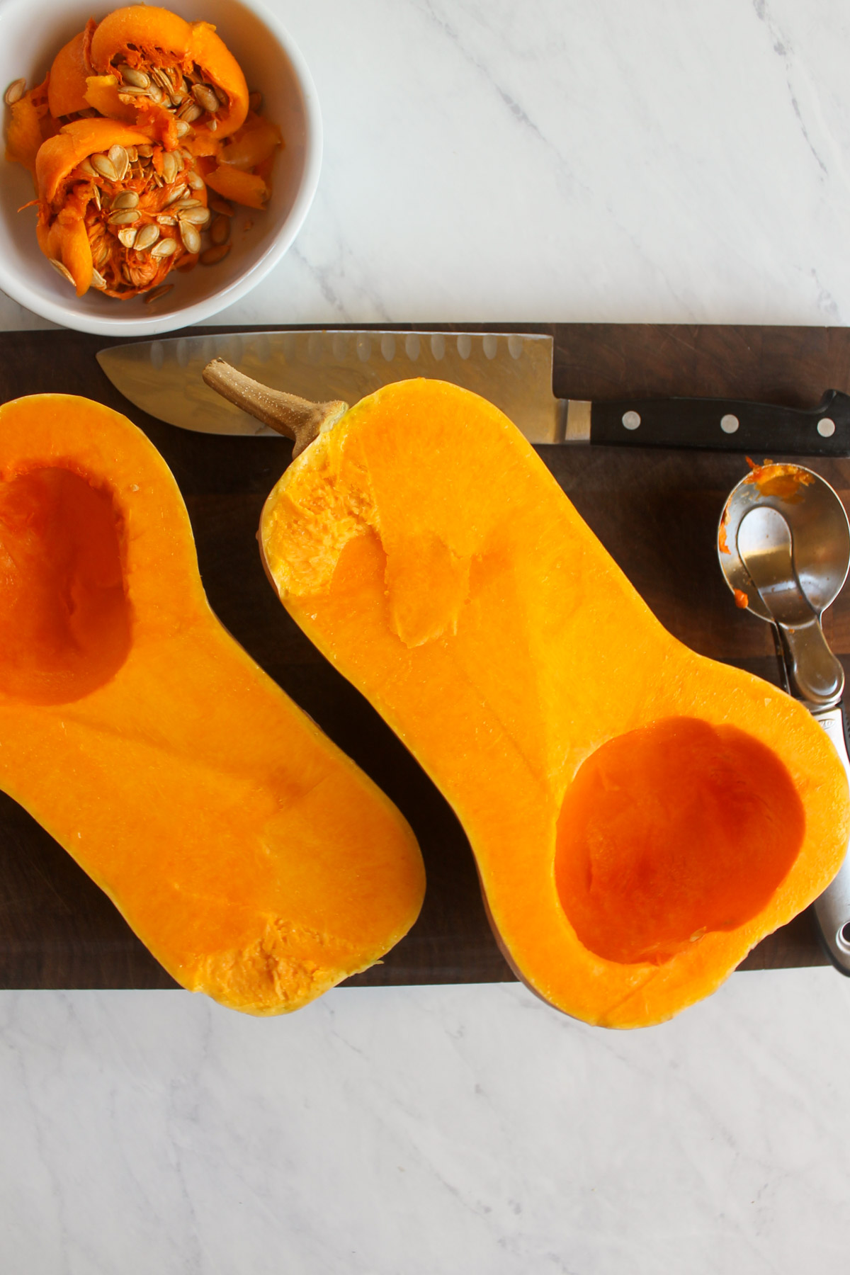 A butternut squash cut open in half with the seeds scooped out.