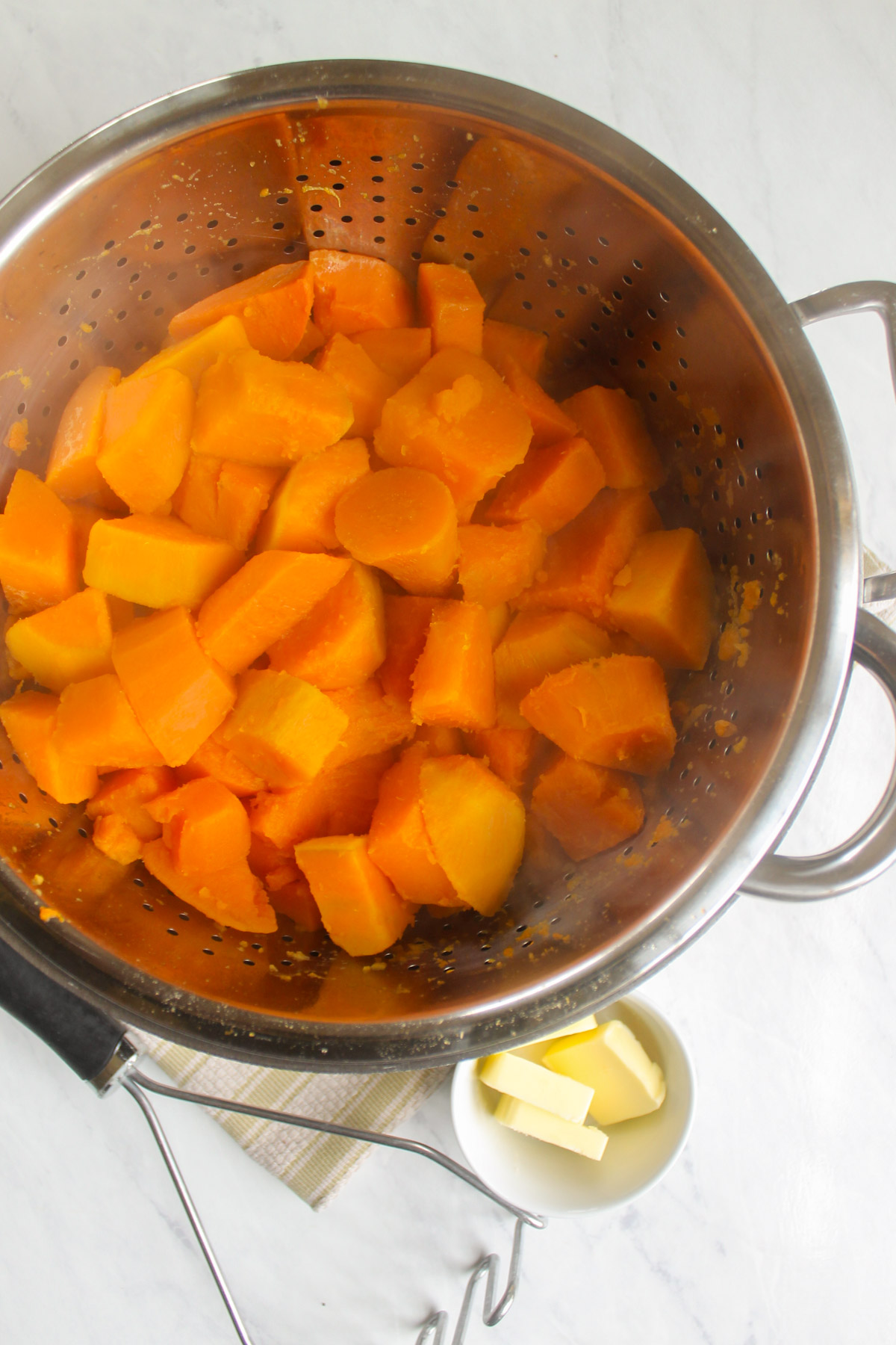 The boiled sweet potatoes drained in a colander.