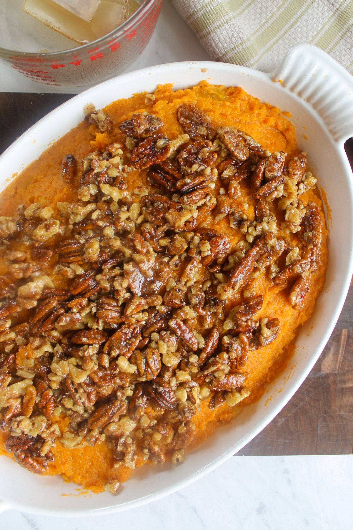 Maple pecan topping over the dish of sweet potatoes ready to bake.