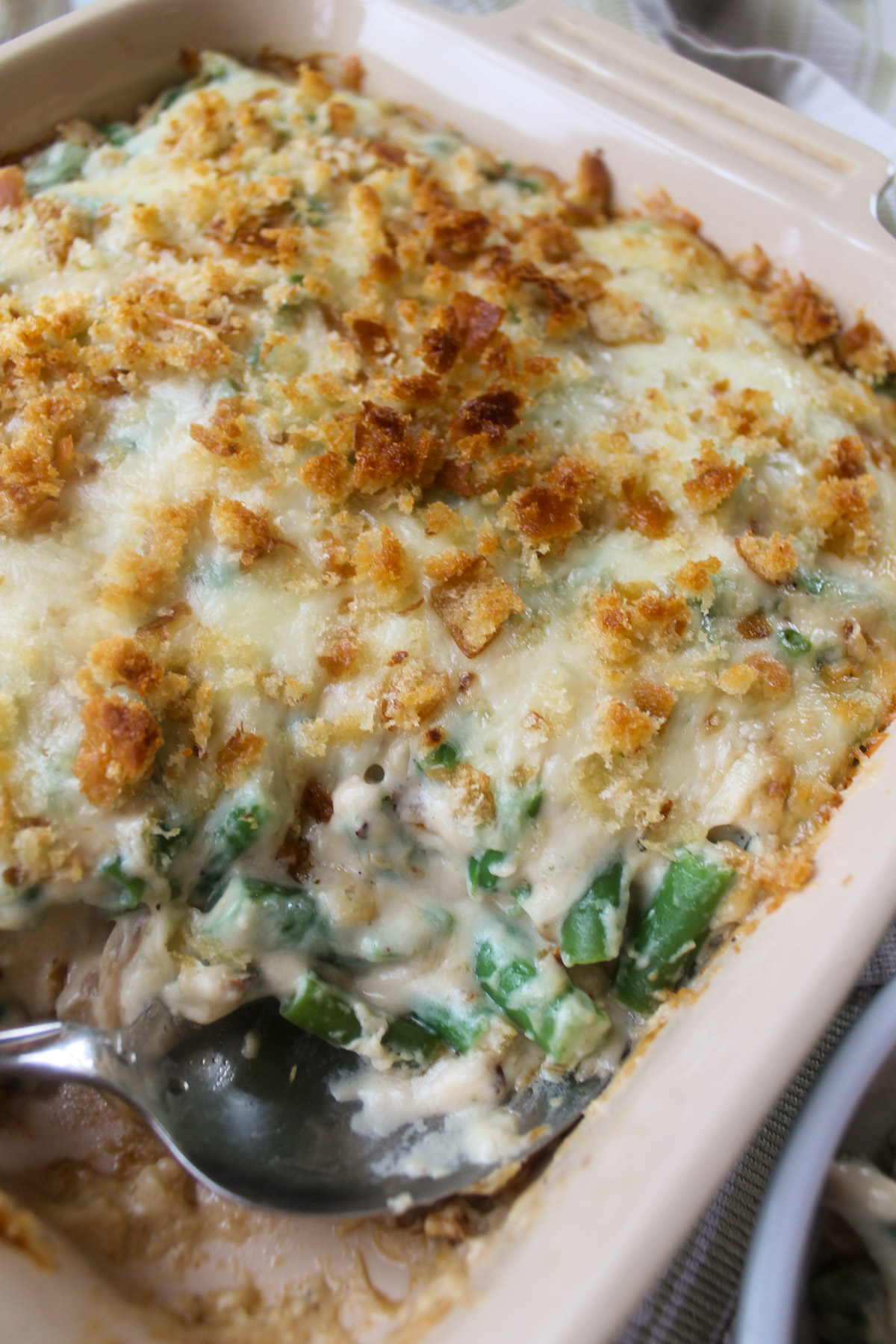 Baked green bean au gratin with a spoon serving the corner.