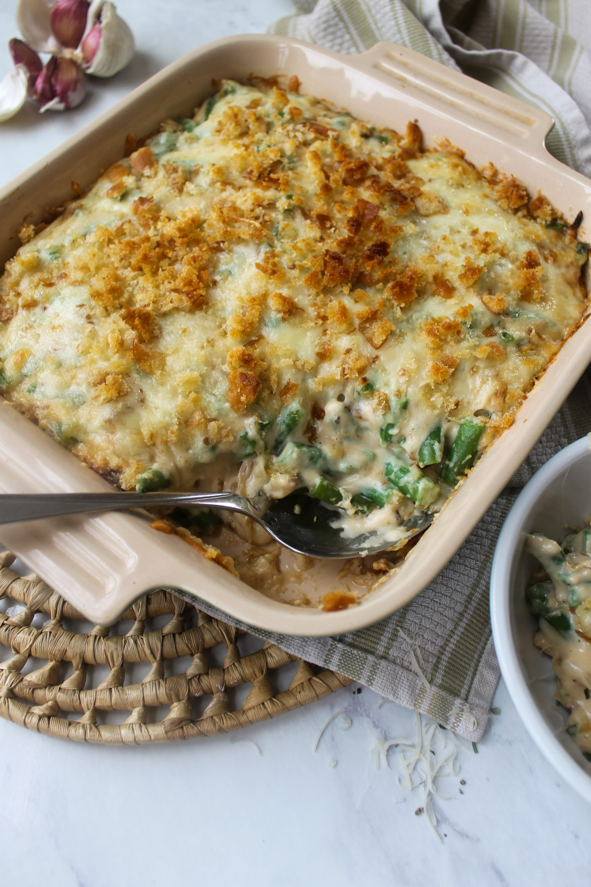 Baked green bean au gratin served with a spoon.