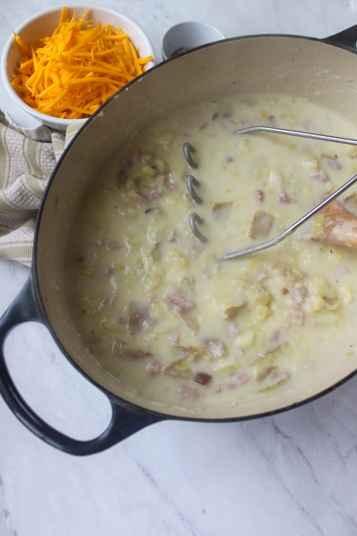 The boiled potatoes added to the soup and mashed with a potato masher.