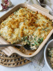 Baked green bean au gratin served with a spoon.