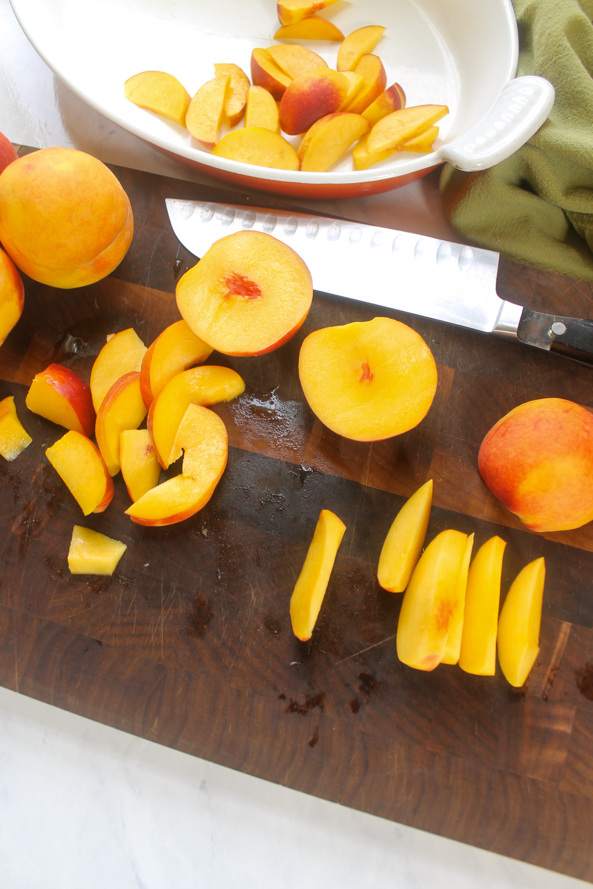 Slicing fresh peaches on a cutting board.