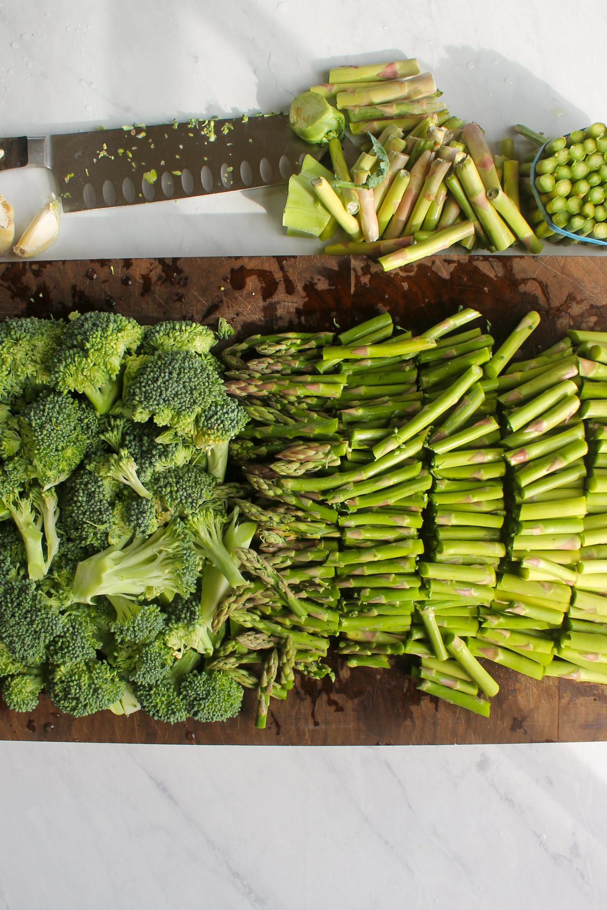 Chopped broccoli and asparagus on a cutting board.