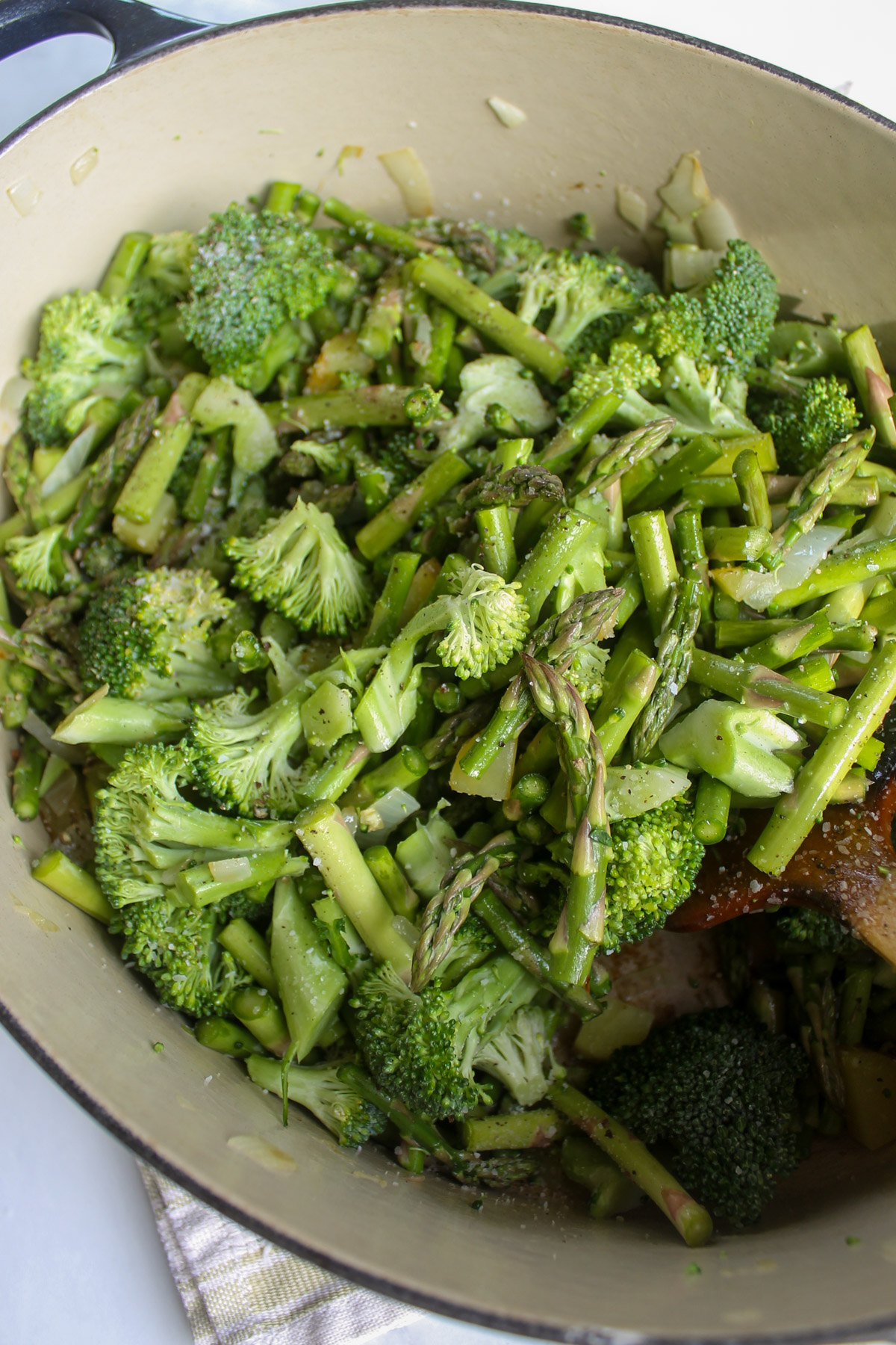 Chopped broccoli and asparagus in a soup pot.