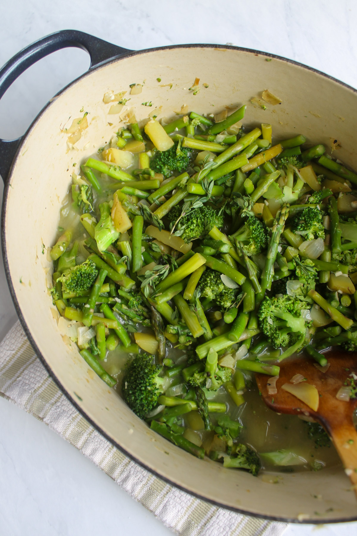 Chicken stock added to the soup pot of broccoli, asparagus, potato and onion.