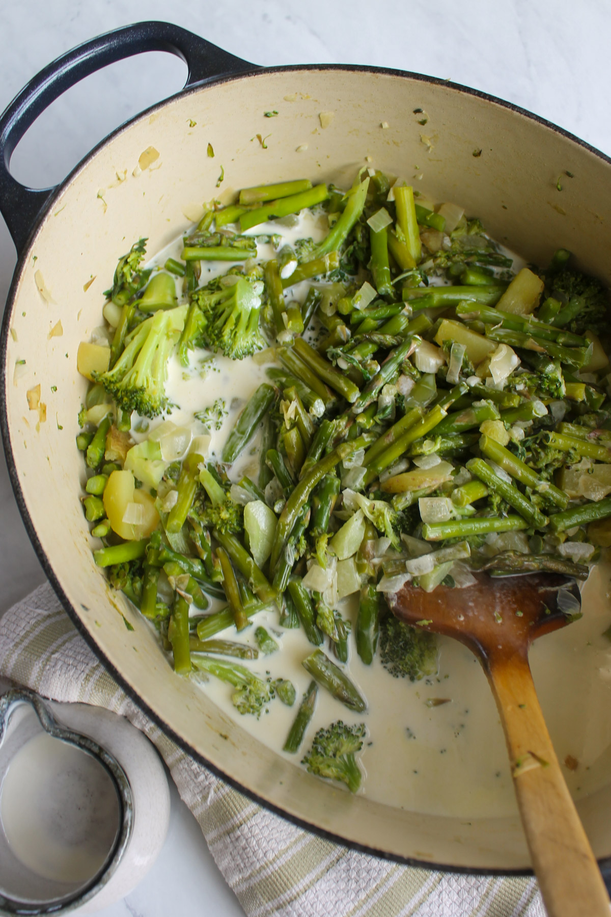 Cream added to the soup pot of broccoli and asparagus.