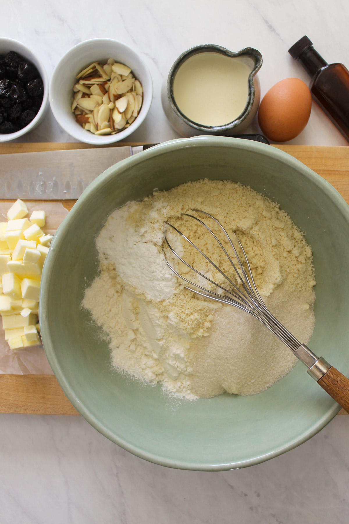 Dry ingredients for scones being whisked in a green bowl.