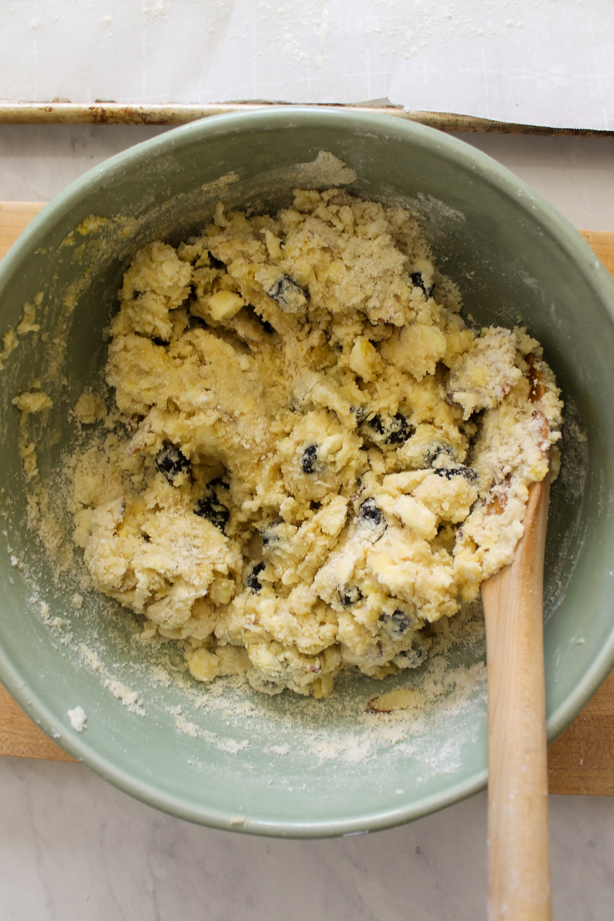 Scone dough being mixed with a wooden spoon in a bowl.
