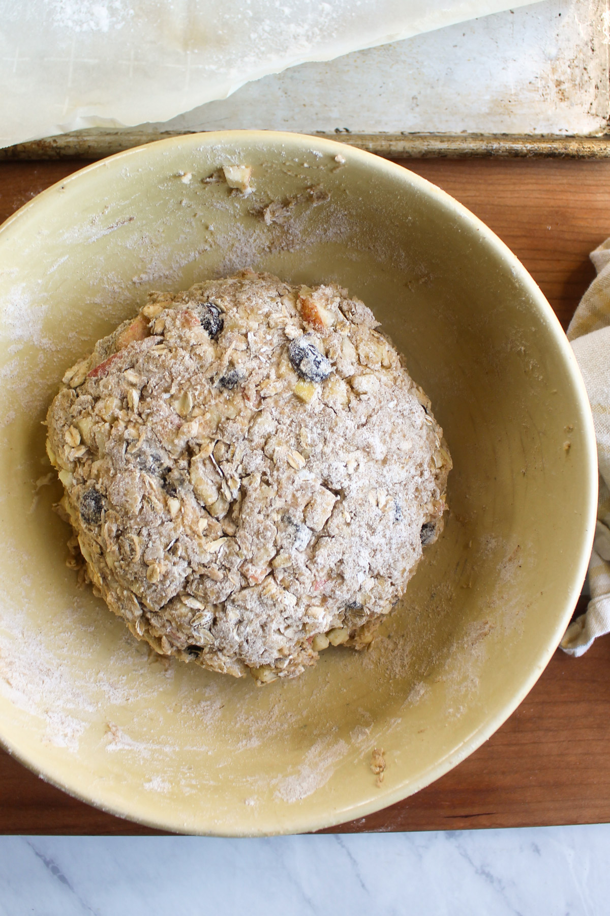 The scone dough formed into a ball in a yellow bowl.