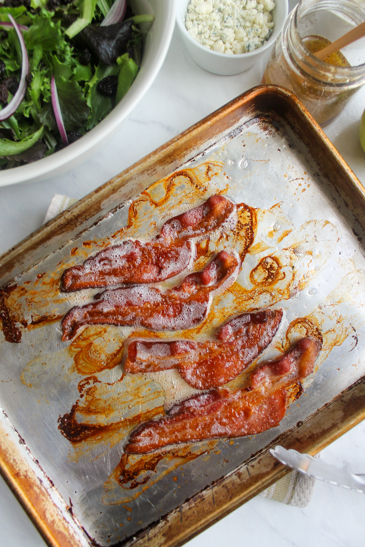 Slices of bacon cooked on a sheet pan.