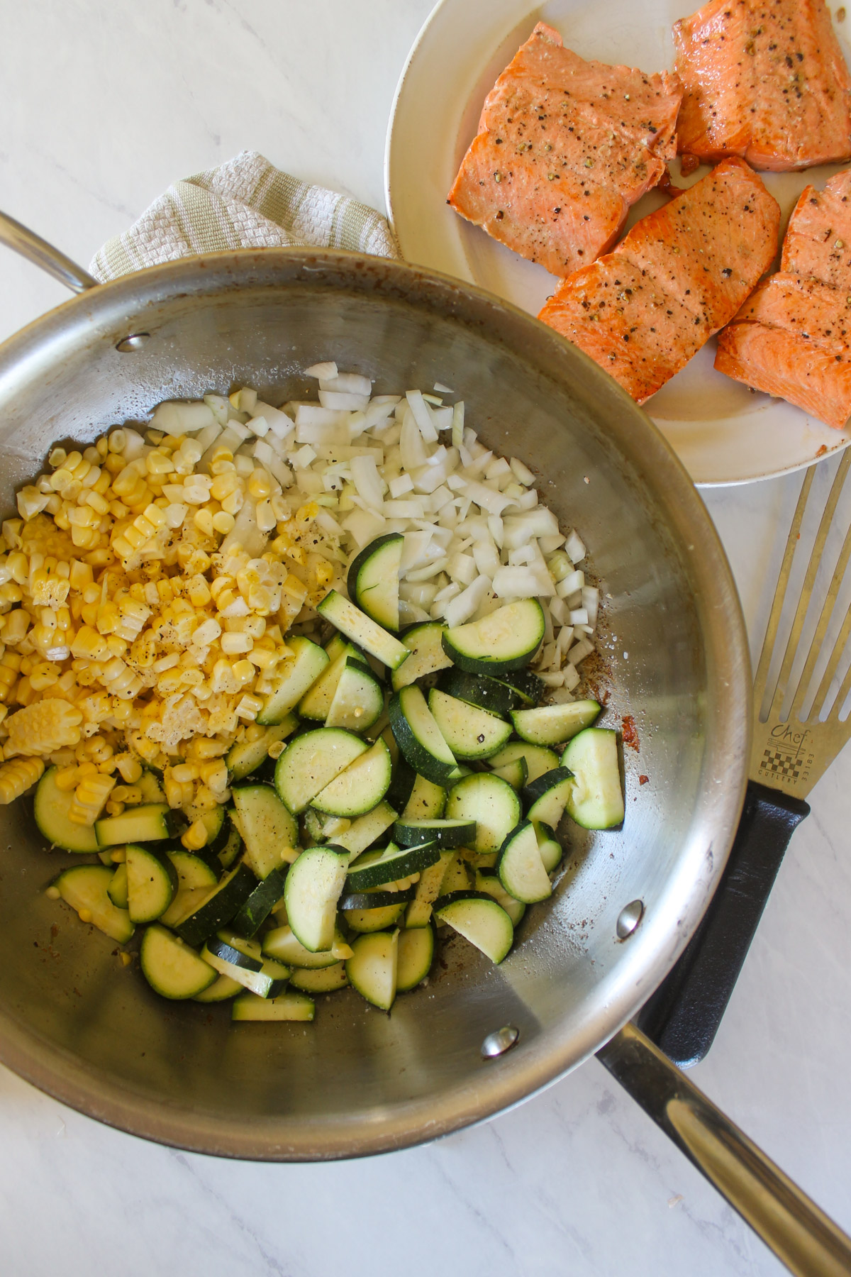 Sautéing onion, zucchini and corn in a skillet.